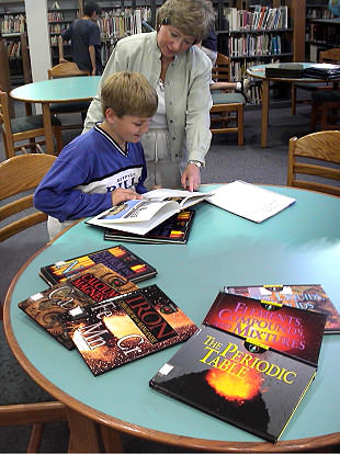 Student and librarian working with science collection